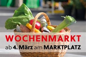 Geflochtener Weiden-Einkaufskorb, bunt gefüllt mit Gemüse, Obst, Käse und Wurstwaren vom Wochenmarkt in Attnang-Puchheim. Davor steht Text: Wochenmarkt ab 4. März am Marktplatz
