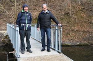 Bürgermeister Peter Groiß und ein Passant testen den neuen Weißenbachsteg in der Zeislau